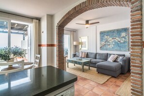A living room with a grey sofa, a coffee table, and a painting on the wall. - Vacation Home 'Vistas De Ensueño' with Sea Views, Wi-Fi, and Air Conditioning (Almuñécar)