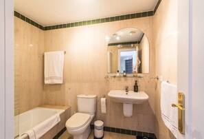 Ein Badezimmer mit Badewanne, Toilette und Waschbecken.