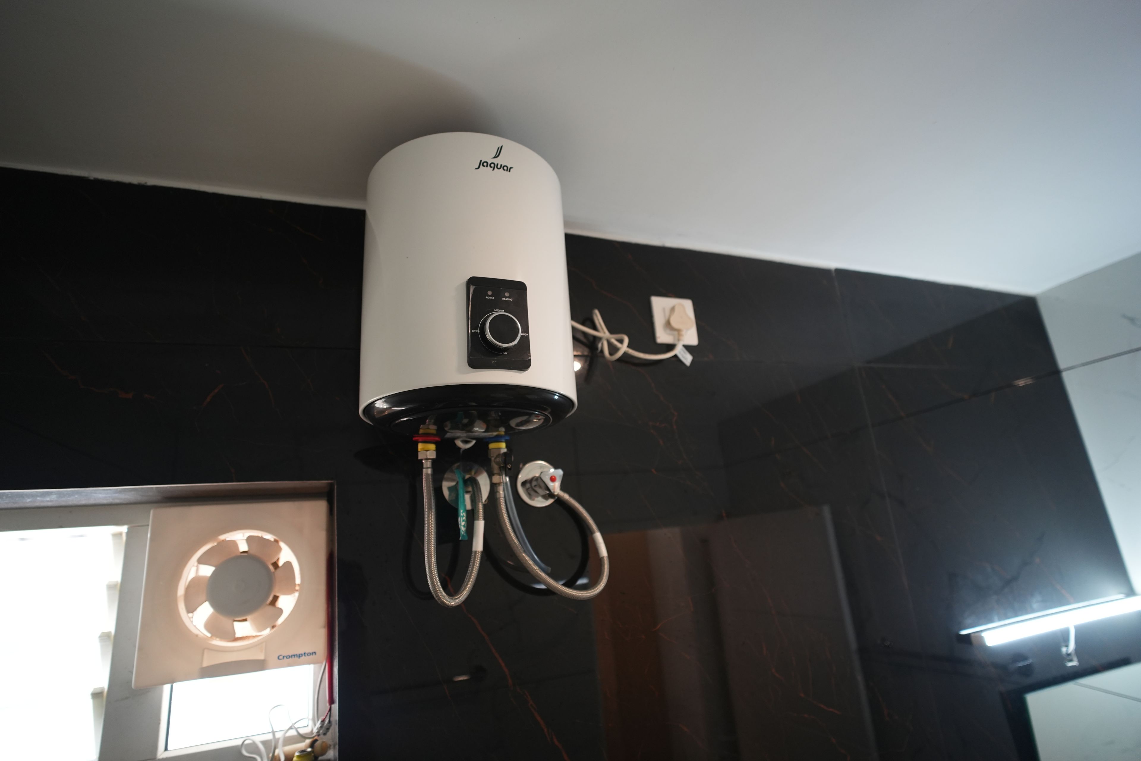Un dispositivo blanco instalado en el techo, con un panel de control y conectado a varios cables.