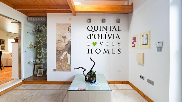 An interior space with a wooden ceiling, a glass table with a sculpture, and a wall with a poster. - Country House 'D’Olívia Lovely Homes -Casa Olívia' with Shared Garden, Wi-Fi and Air Conditioning (Cela)