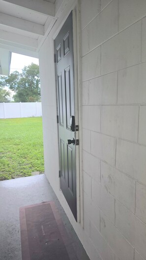 A white door with a black handle and a small window above it. -  Spacious Orlando Getaway 3 Bd 1bt- 6 Beds with huge  Backyard for entertainment (Orlando)