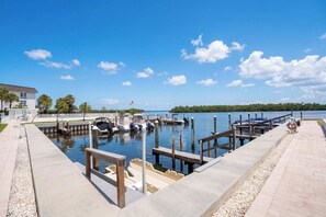 A marina with boats docked, a clear sky, and a distant shoreline. - Bay View at Sutton Place | Longboat Key | Beach Access | 30-Day Min (Longboat Key)