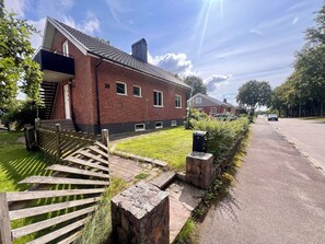 A residential street with houses, a wooden fence, and a mailbox. - Stylish Villa, Terrace & Garden (Ljungby)