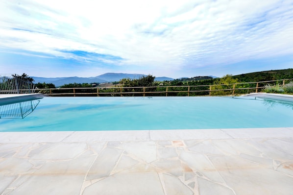 Piscina com vista para montanhas e céu claro.