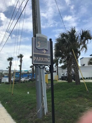 Señal que indica un área de estacionamiento con una flecha direccional.