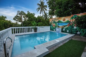 A swimming pool with a white fence, surrounded by lush greenery and a mural wall. - Bosq Retreat, Private Pool 5min to  Surf city El Salvador (La Libertad)