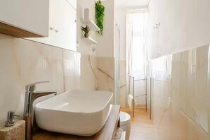 Ein modernes Badezimmer mit einer großen rechteckigen Badewanne, einer Duschkabine aus Glas und einem minimalistischen Design.