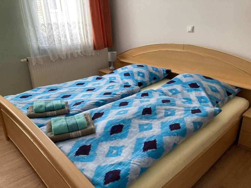 Ein Doppelbett mit einem gemusterten Bettbezug und zwei Handtüchern.