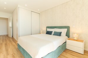 Ein Schlafzimmer mit Bett, Nachttischen, einem Kleiderschrank und Holzboden.