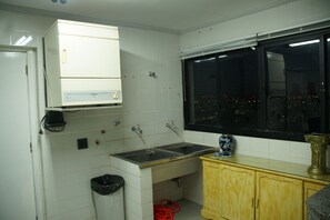 Una cocina con un lavamanos doble, una ventana y un armario.