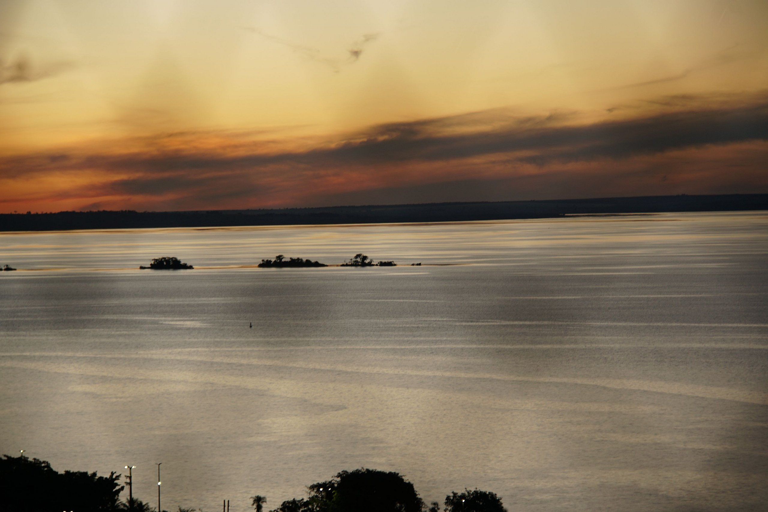 A large body of water with distant land and a cloudy sky.