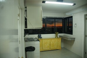 A kitchen with a window, a sink, a cabinet, and a radiator.