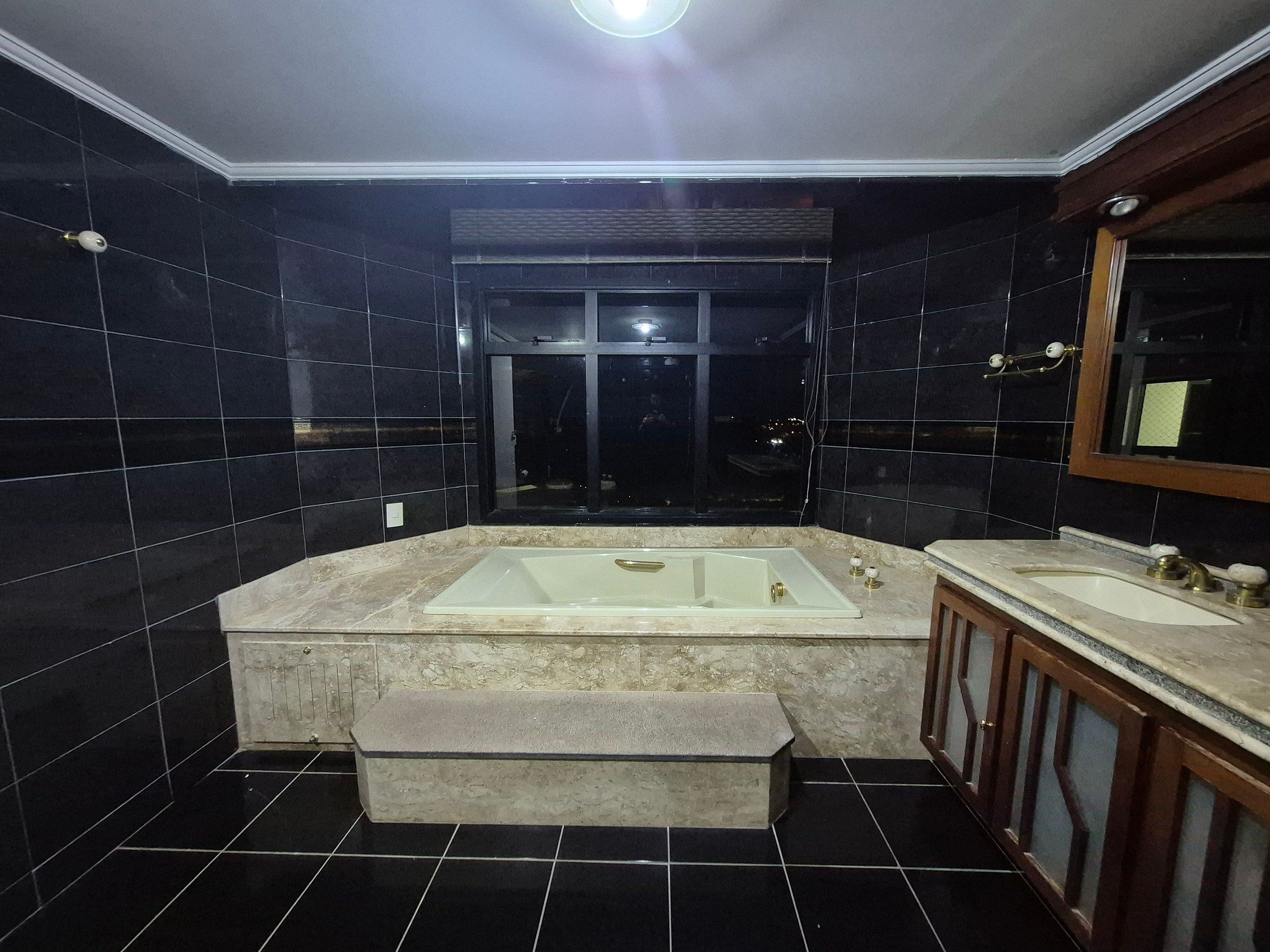 Une salle de bain moderne dotée d’une grande baignoire, d’une douche séparée et d’un meuble-lavabo avec un miroir.