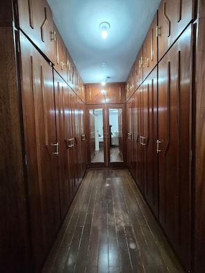 A hallway with wooden wardrobes, a ceiling light, and a door at the end.
