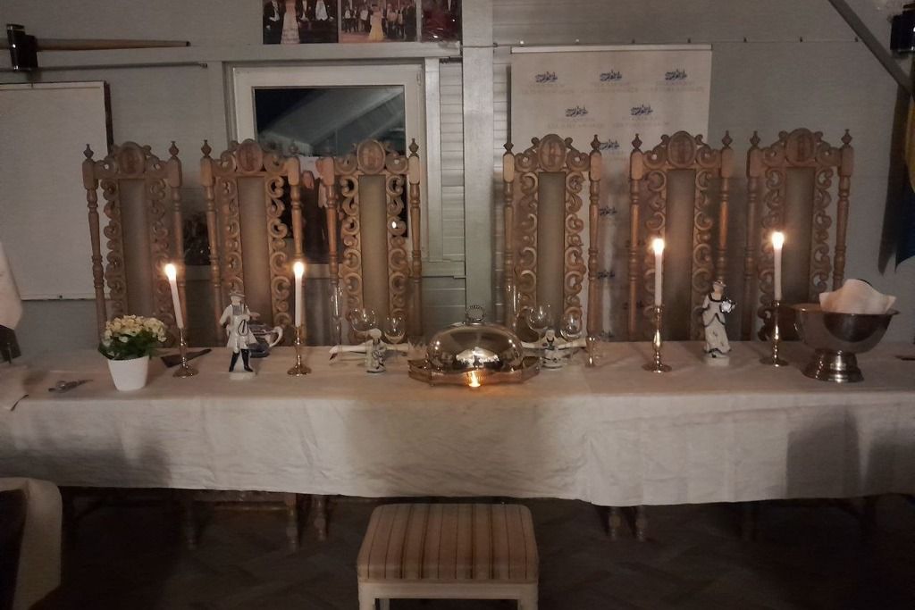 A table set with candles, a central decorative item, and small figurines.