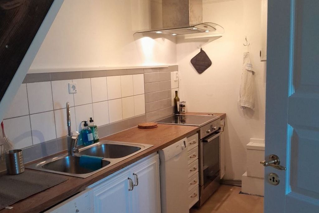 Een functionele keuken met een spoelbak, vaatwasser en oven.