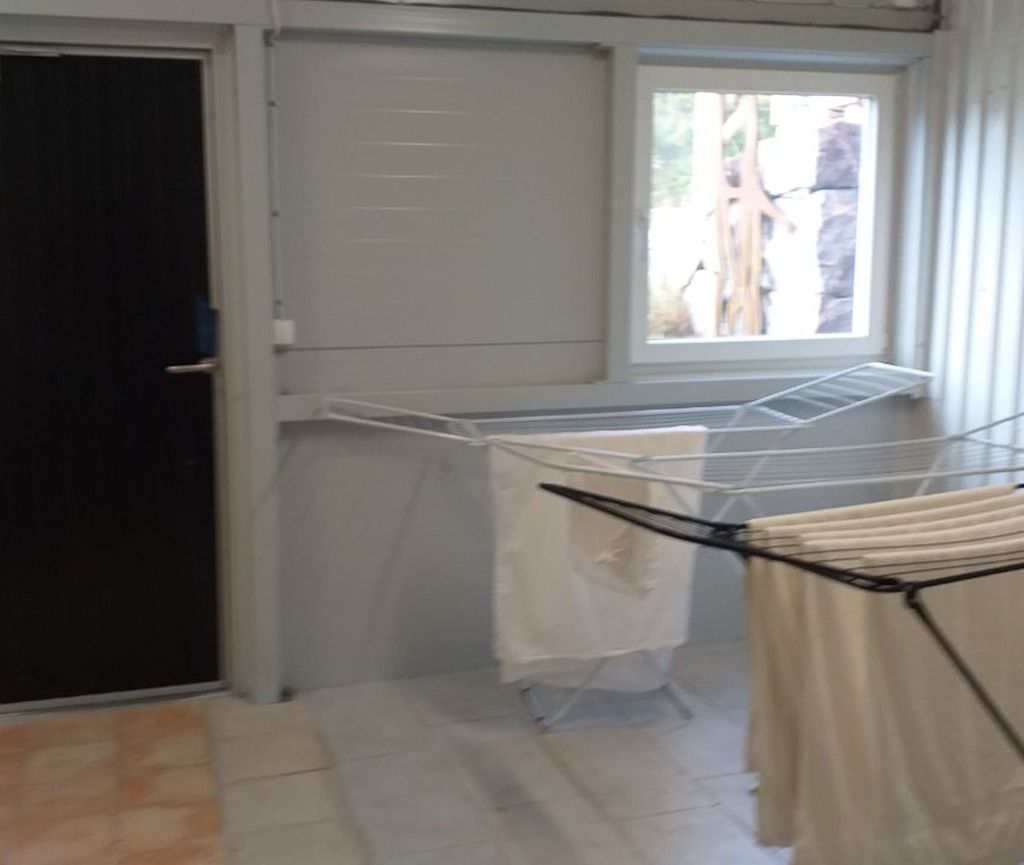 A laundry area with a drying rack and a window.