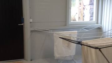 A laundry area with a drying rack and a window.