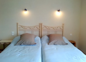A double bed with two pillows, a wooden headboard, and two wall-mounted lights. - Chambre Bateau: between Brest, Landerneau, and the Bay of Morlaix (Lampaul-Guimiliau)