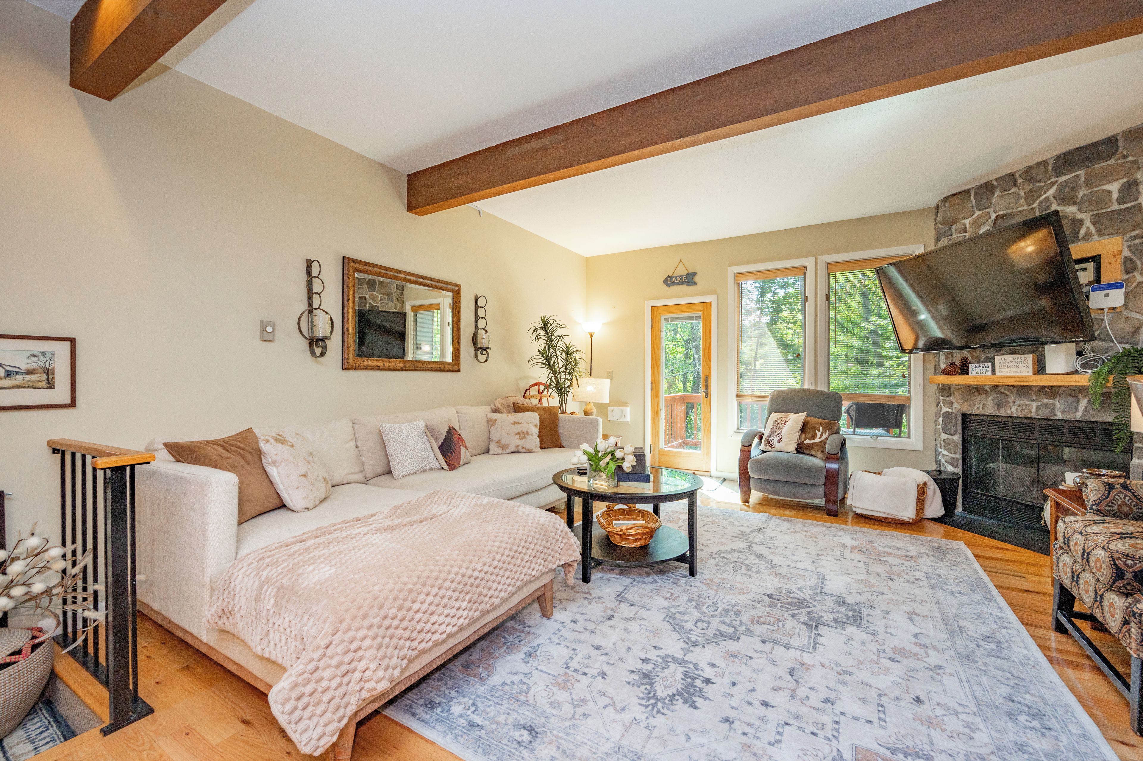 A cozy living room with a fireplace, a sofa, a coffee table, and a television.