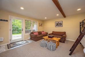A cozy living room with two sofas, a coffee table, and a wooden ladder. - New! Ski In/Out Home w/ Hot Tub! (McHenry)