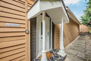 A wooden building with a sign reading 'THE STUDIO' and a door with a white porch.