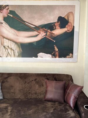 A painting of a classical scene with a couch and pillows in the foreground.
