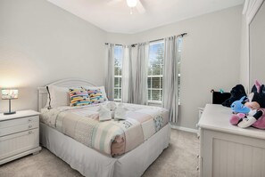 Une chambre à coucher avec un lit, des tables de chevet, une lampe et une commode.