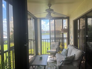 A covered outdoor seating area with a table, chairs, and a ceiling fan. - Cozy 2-bedroom and 2 bath condo with AC in terrific Fort Myers (Fort Myers)