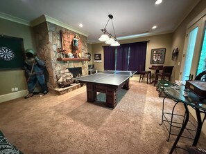 A room with a ping pong table, a dartboard, and a statue of a diver. - Secluded Lake Norman Waterfront Luxury, 4BR, 5.5 Baths with Home Theater (Mooresville)