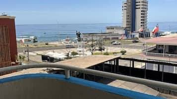Varanda com vista para a costa, incluindo um prédio alto e um porto de iates.