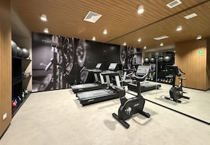 Ett gym med löpband, motionscyklar och styrketräningsmaskiner.