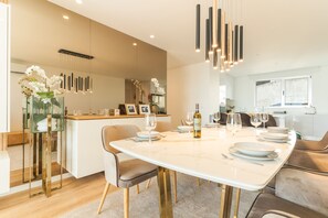 A modern dining area with a marble table, chairs, and a wine bottle. - Sunny Stay Atlantic Gardens by Atlantic Holiday (Camara de Lobos)