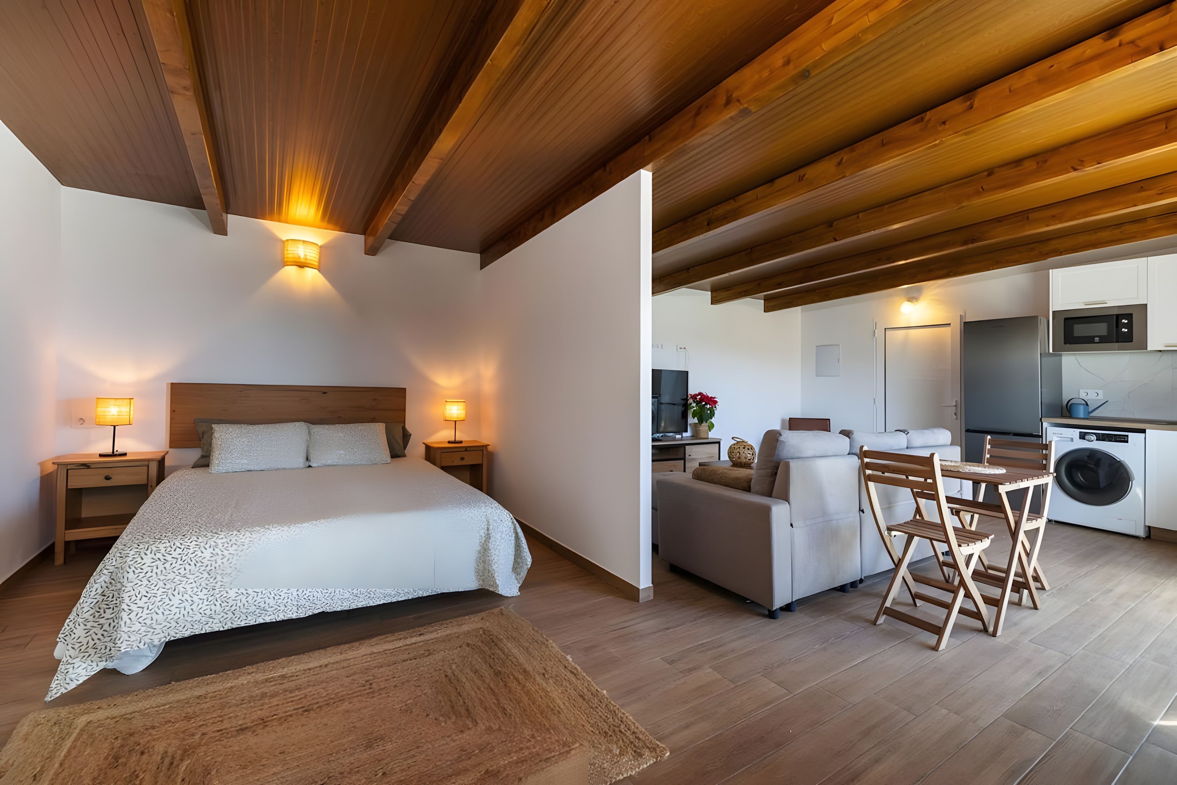 Une chambre à coucher avec un lit, des lampes de chevet et un plafond en bois.