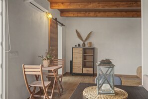 Una habitación con una mesa de madera, sillas, un armario y un farol decorativo.