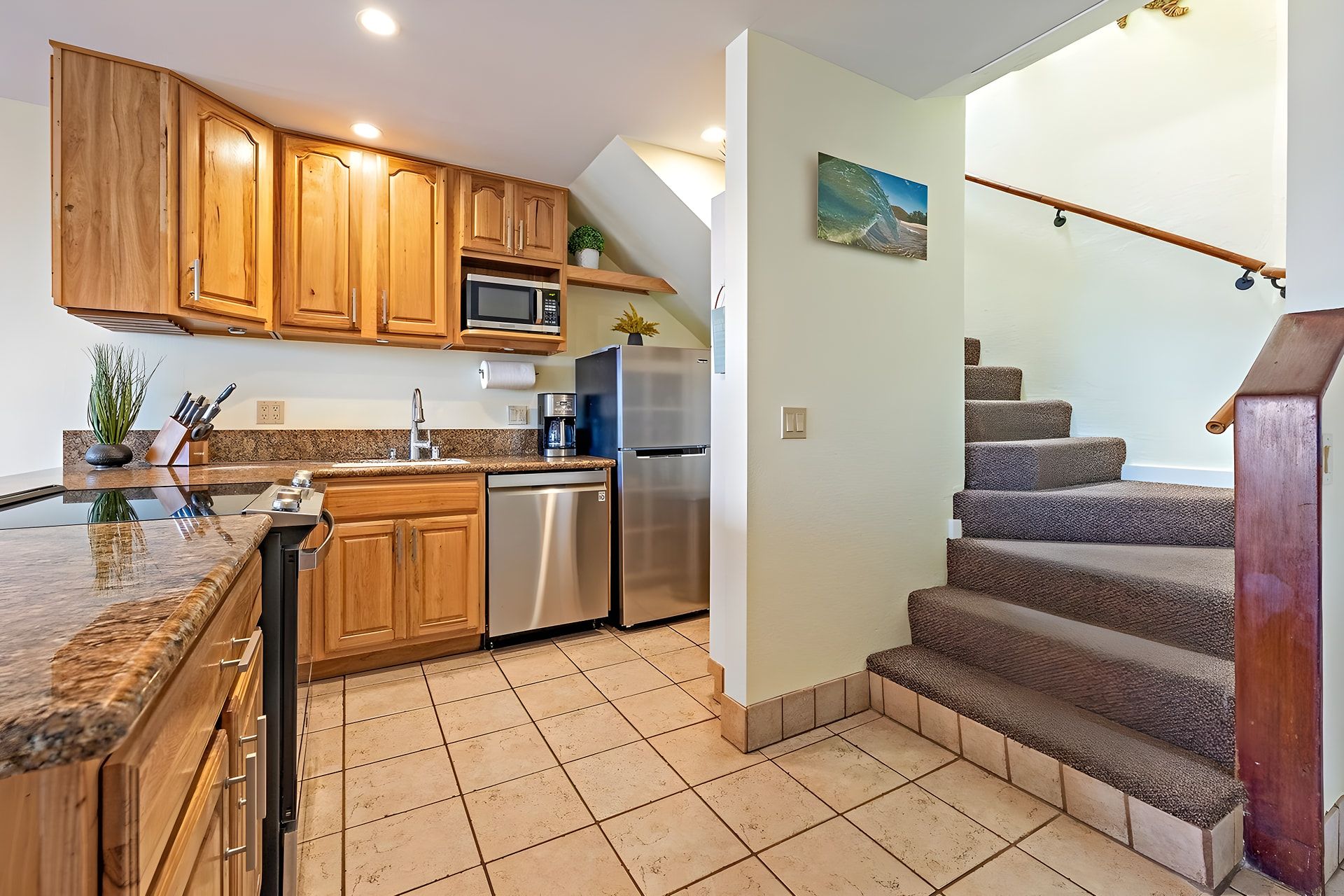 A kitchen with wooden cabinets, a stainless steel refrigerator, and a built-in microwave.