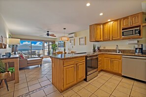 A modern kitchen with wooden cabinets, a stainless steel oven, and a large island.