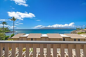 A beachfront property with multiple buildings, a clear blue sky, and a view of the ocean.
