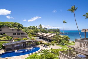 A resort with a swimming pool, beachfront view, and multiple guest buildings.