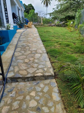 A stone pathway leading to a building with a blue exterior.