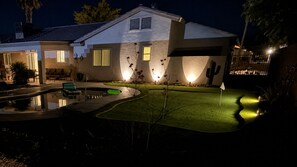 A residential property at night with a swimming pool, a cactus, and a well-lit lawn. - Escape to Tangled Desert Nest- 3B/2B where your lake days & desert sunsets meet! (Lake Havasu City)