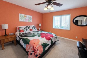 A bedroom with a bed, a nightstand, a lamp, a ceiling fan, a window, and a mirror. - Escape to Tangled Desert Nest- 3B/2B where your lake days & desert sunsets meet! (Lake Havasu City)