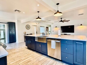 A modern kitchen with a central island, dark cabinetry, and a ceiling fan. - Bear Down Arizona- It's Gametime! (Tucson)