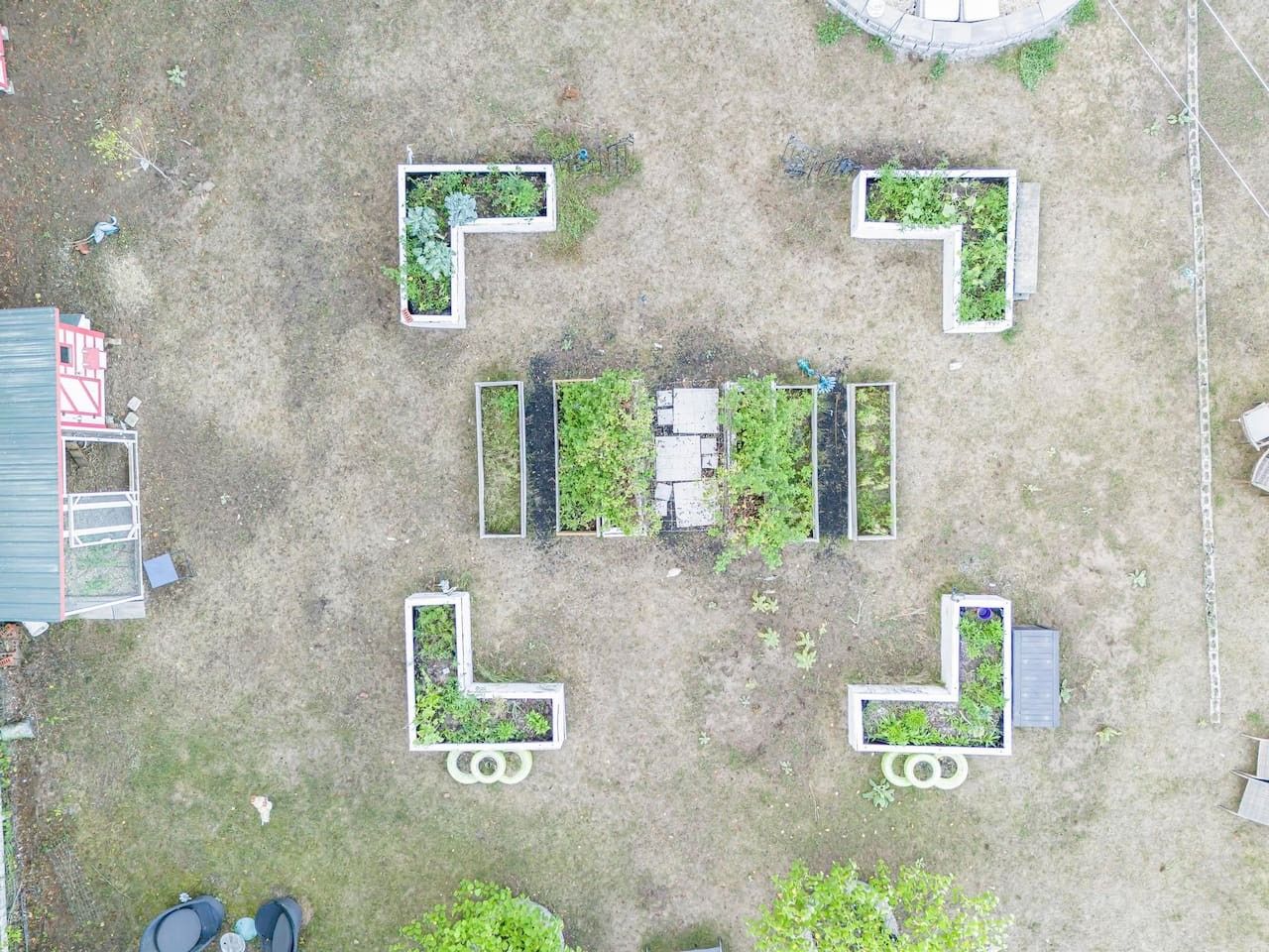 An aerial view of a property with multiple rectangular garden beds arranged in a grid pattern.