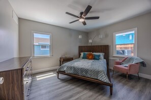 A bedroom with a bed, a desk, a chair, a ceiling fan, and windows. - Cozy 1-bedroom Suite in the Art District Downtown Las Vegas (Las Vegas)