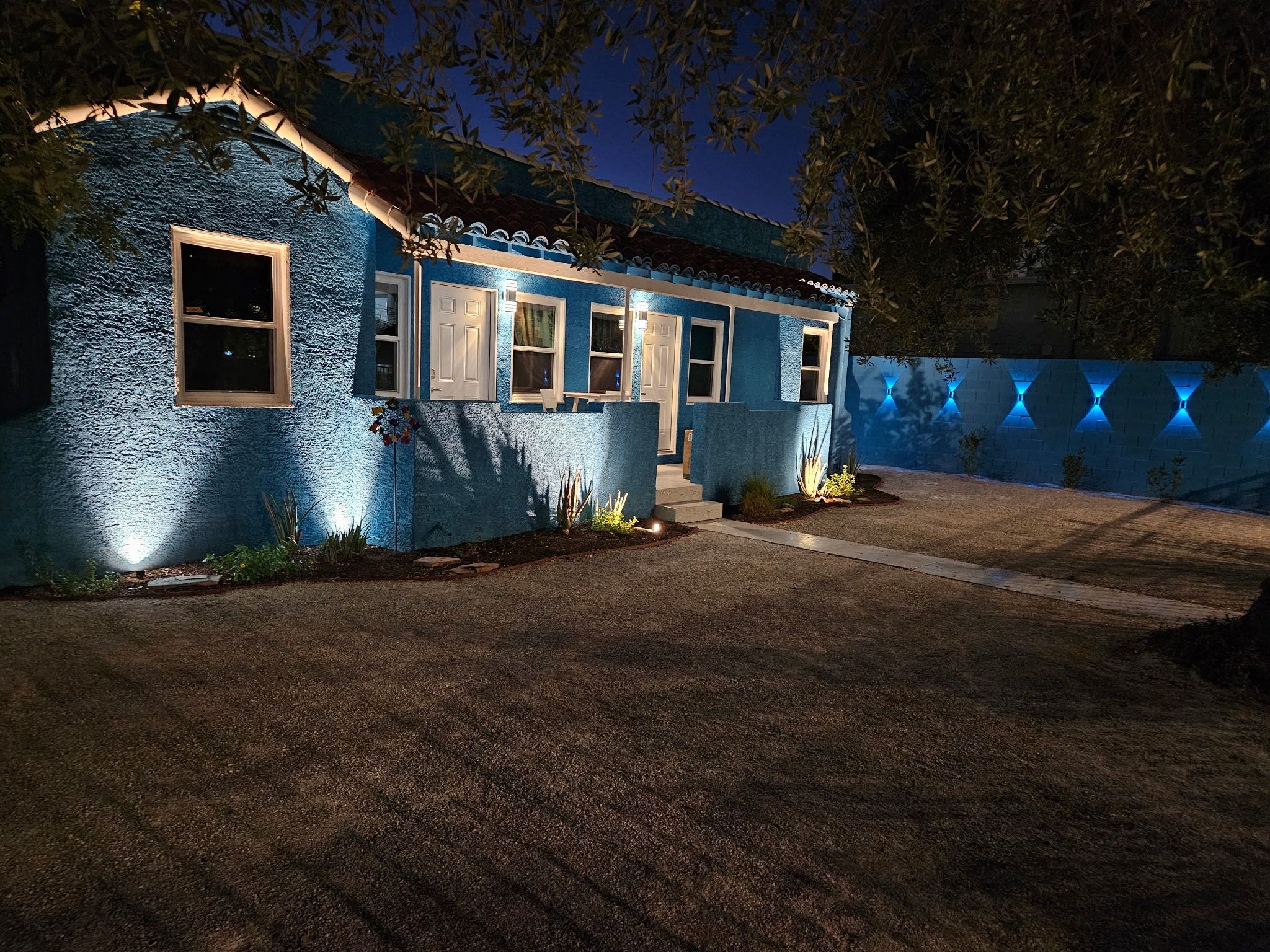 Una casa con fachada texturizada, un porche y una entrada bien iluminada.