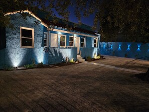 A house with a textured exterior, a front porch, and a well-lit entrance. - Cozy 1-bedroom Suite in the Art District Downtown Las Vegas (Las Vegas)