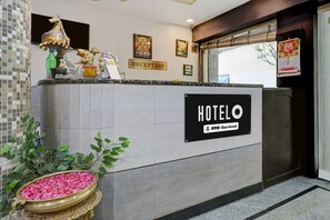 Un mostrador de recepción de hotel con un letrero que indica que es administrado por OYO.