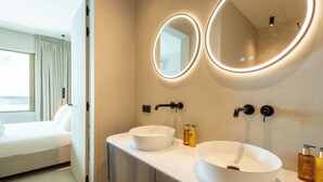 Un baño moderno con dos lavamanos, un espejo y una ventana.