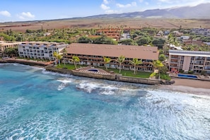 A coastal hotel with multiple balconies, a swimming pool, and a view of the ocean. - Kaanapali, Kulakane, Spacious 4 BR, Beachfront, Sleeps 14 (Lahaina)